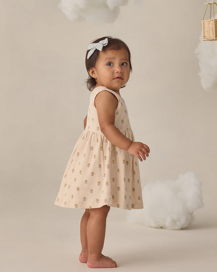 Girl wearing cream colored dress with delicate floral print