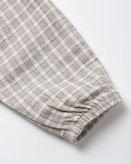 Close-up of a blue/gray and off-white plaid fabric sleeve with an elasticized cuff