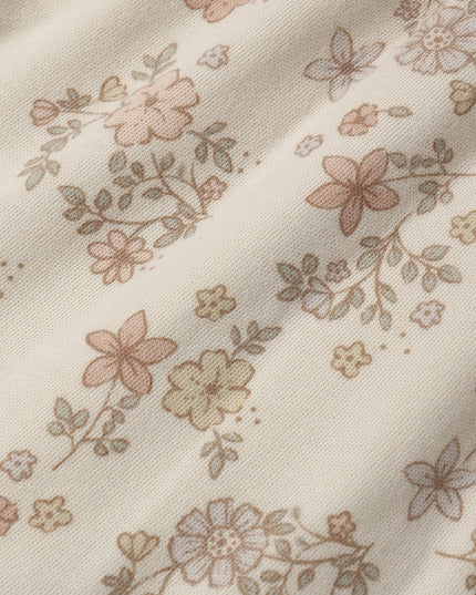 A close-up of a cream-colored dress with a delicate, muted floral pattern 