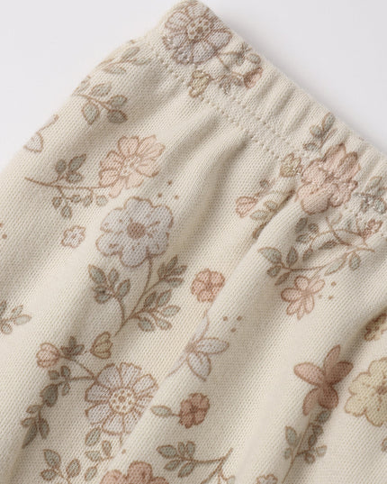 A close-up of a cream-colored dress with a delicate, muted floral pattern 