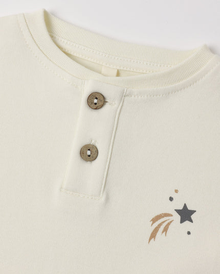 A kid's long-sleeve henley shirt with an off-white body and dark gray sleeves, featuring a three-button placket and a small shooting star design on the left chest.