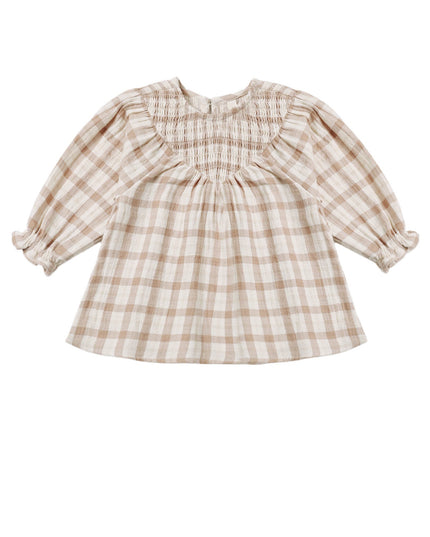 A toddler girl's long-sleeve dress in a beige and white gingham plaid pattern, featuring a smocked bodice, ruffled collar, and ruffled cuffs.