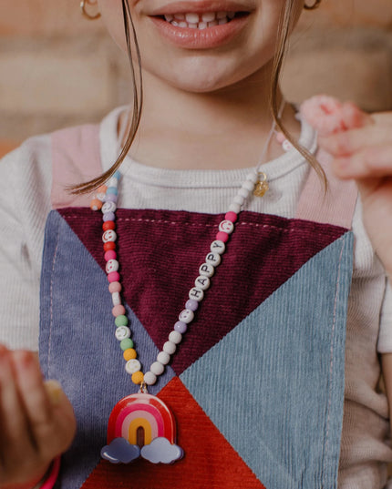 Girl wearing "Happy" Rainbow Necklace