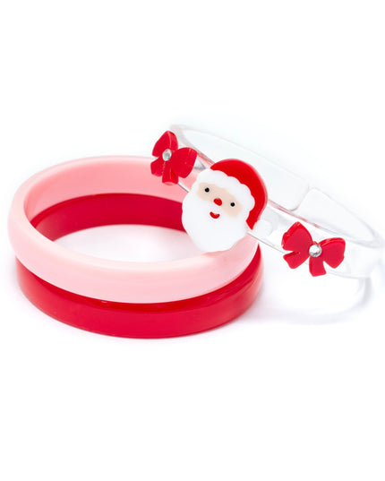 Kids bracelet set featuring a pink bangle, a red bangle, and a clear bangle topped with red bows and Santa Claus.