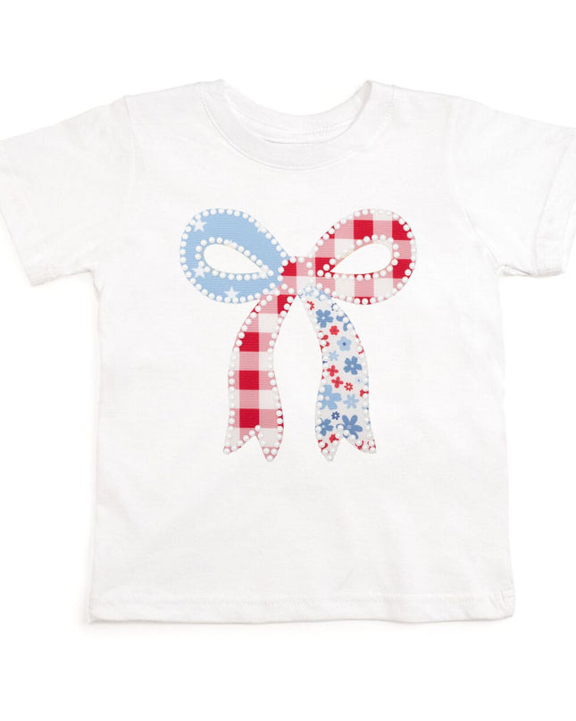 White t-shirt with a patchwork bow design featuring red, white, and blue colors