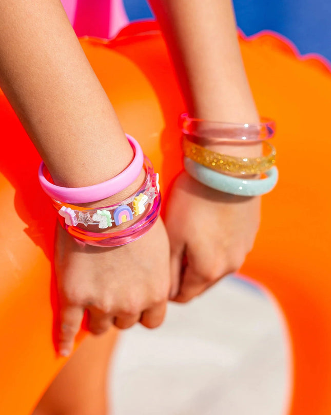Girl wearing colorful bangles holding an orange swimming toy