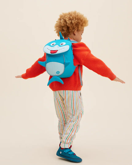 Child wearing a backpack with a shark design