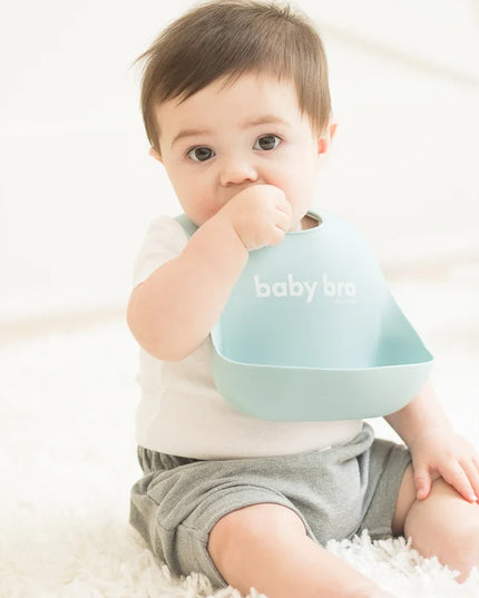 Baby wearing a bib with 'baby bro' text