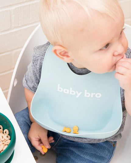 Baby wearing a bib with 'baby bro' text