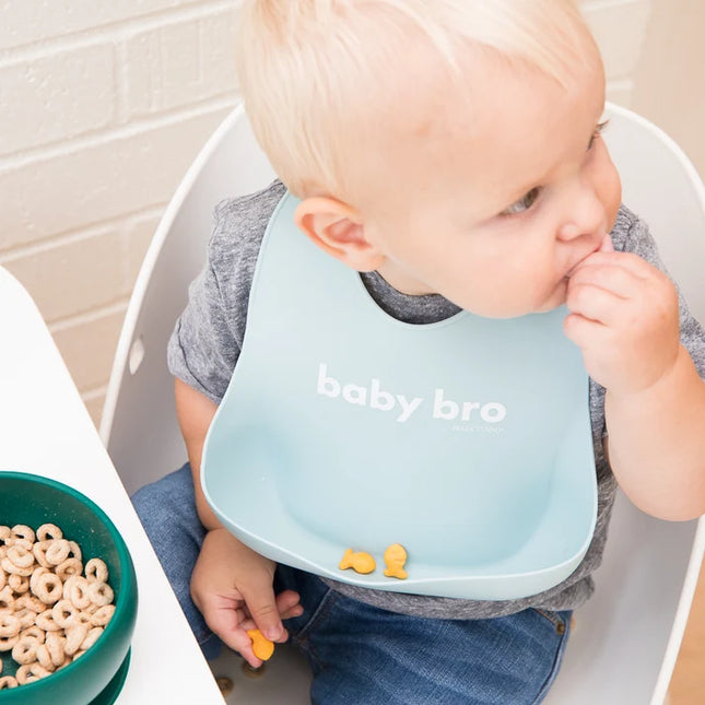 Baby wearing a bib with 'baby bro' text