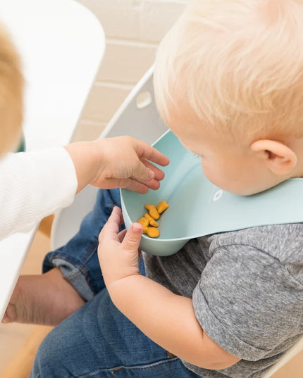 Baby wearing a bib with 'baby bro' text